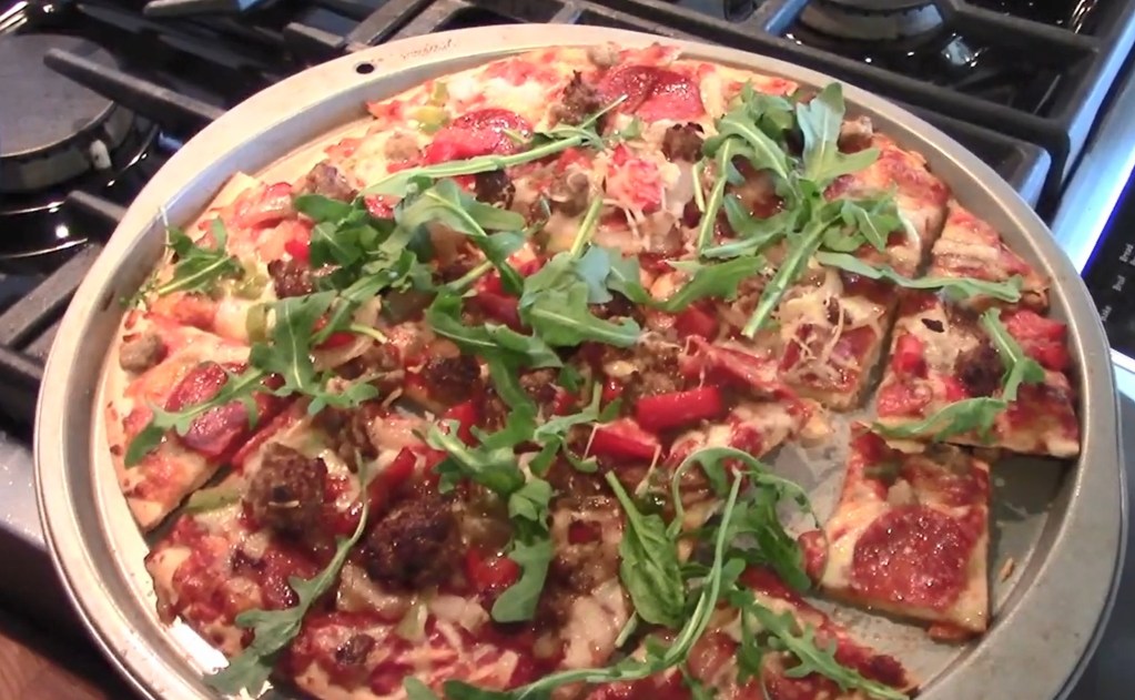 Add arugula to baked frozen pizza