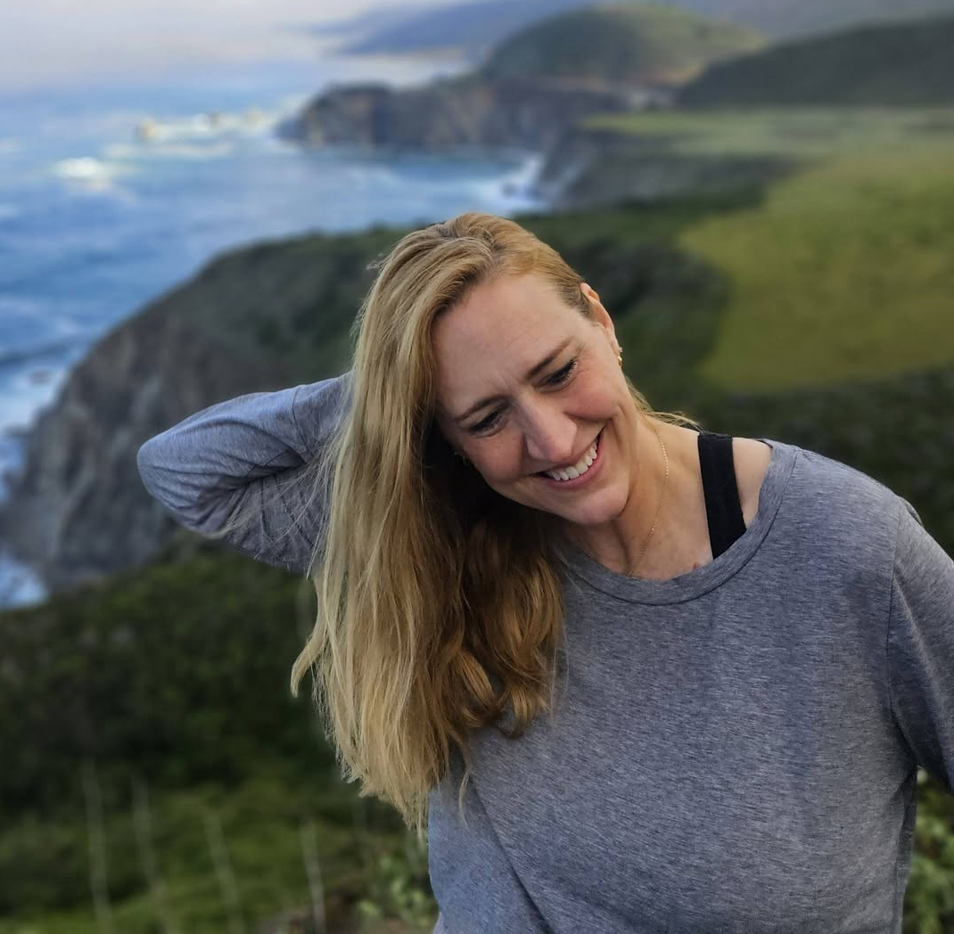Photo of Allie Adkins with the California coast behind her.