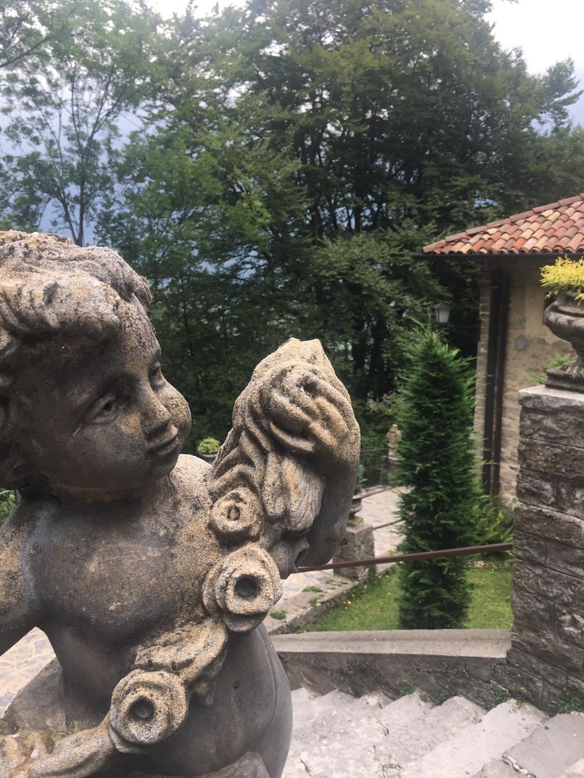 Putto in cemento nel cortile del Santuario del Perello