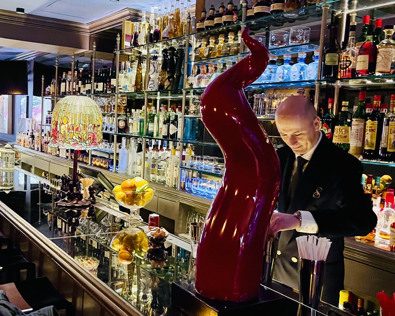 man behind large red glass statue