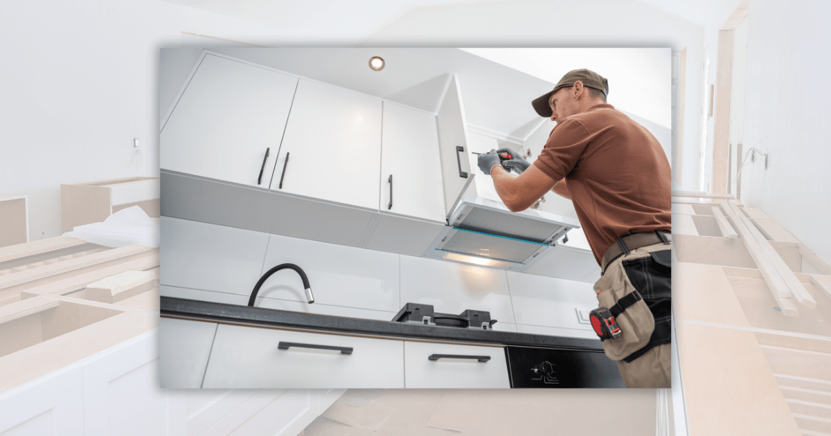 man installing white upper kitchen cabinets