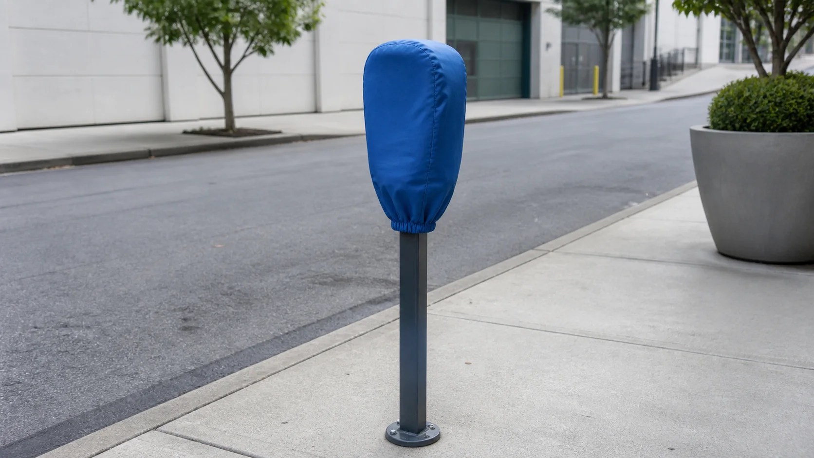 Fitted blue temporary cover over one inactive curbside parking meter on a quiet service lane