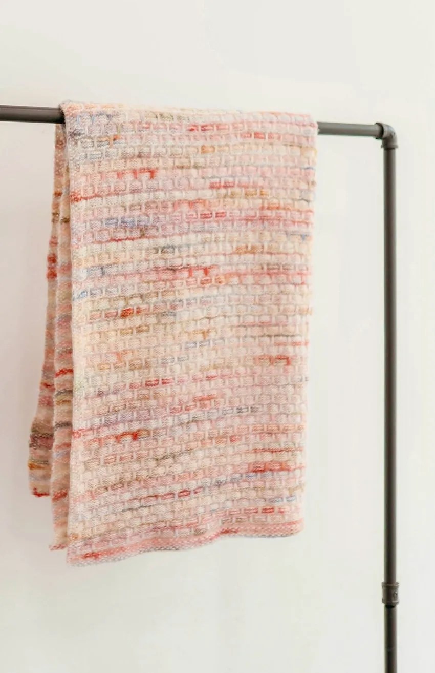 A blanket folded over an iron pole.