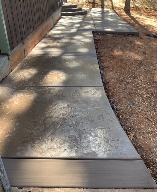 Finished concrete walkway leading to a home