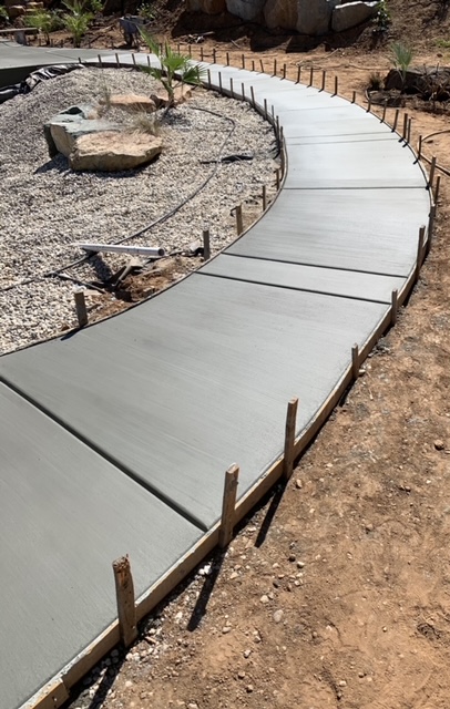 Finished concrete walkway leading to a home