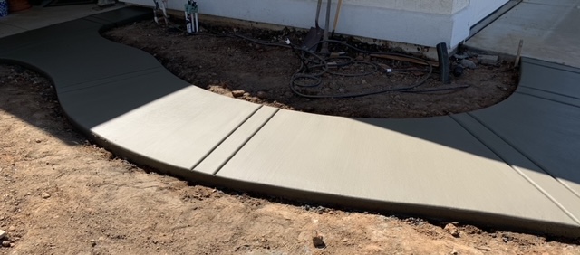 Finished concrete walkway leading to a home