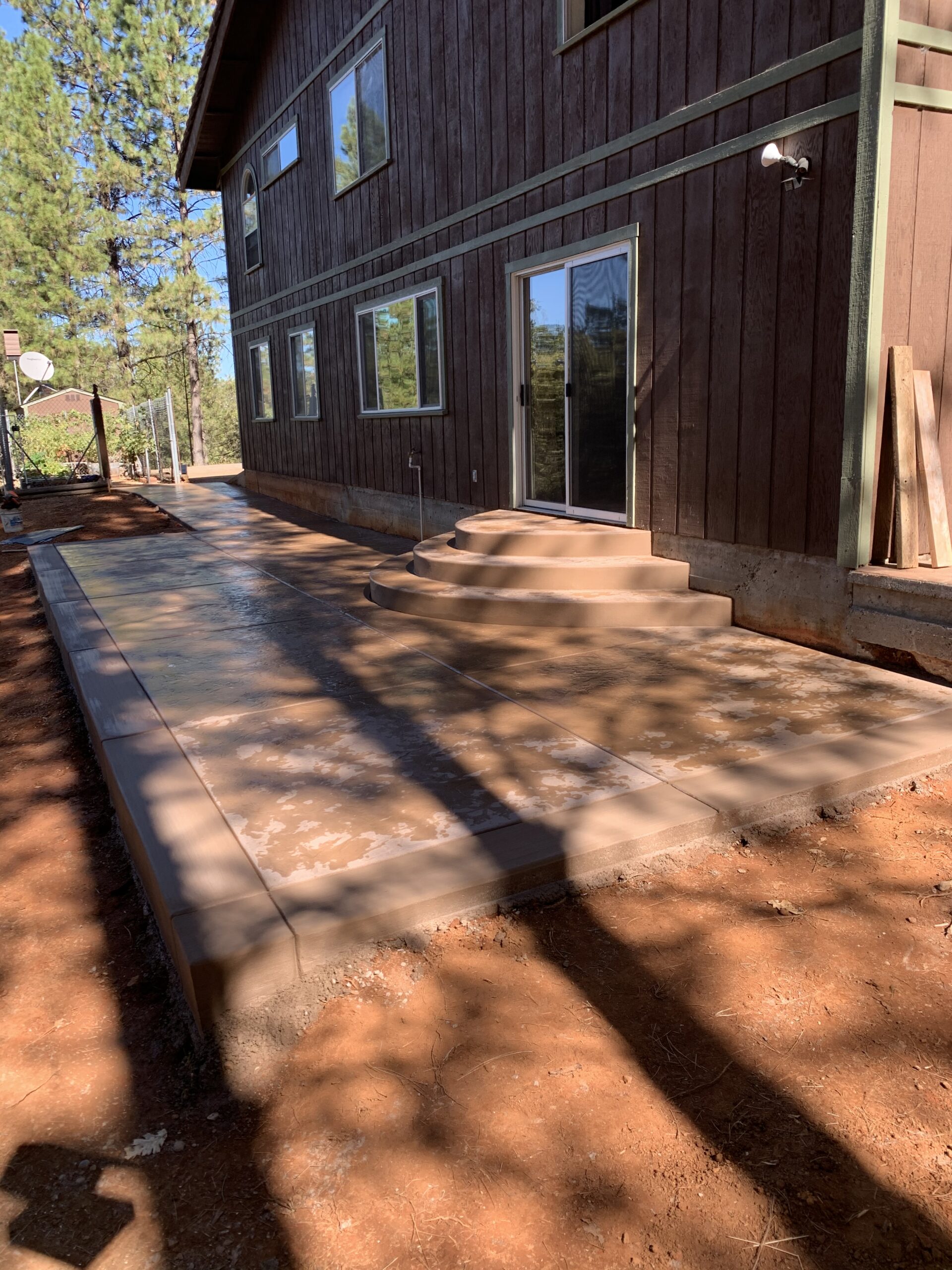 Newly installed concrete patio beside a home