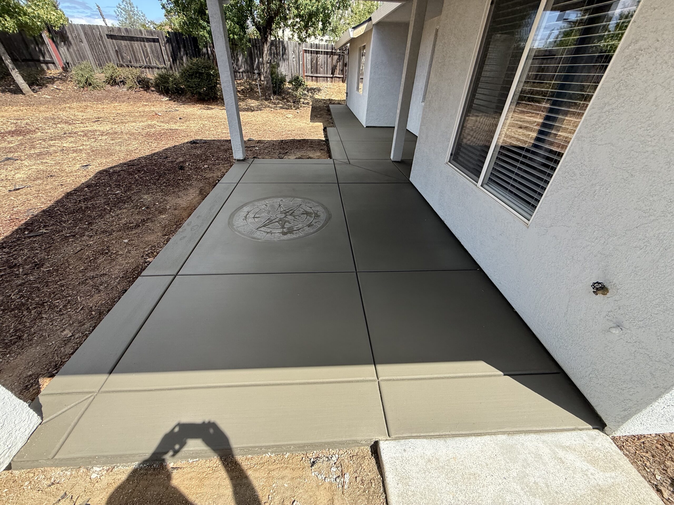Backyard concrete patio designed for outdoor seating