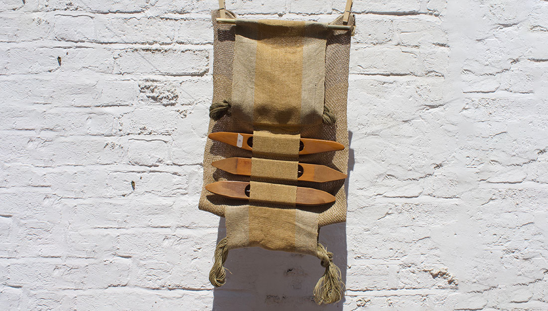 A hand loom with woven fabric.