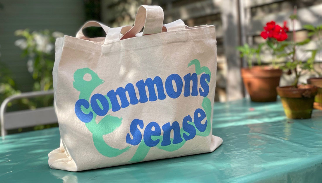 A bag sits on a table in a sunny garden, the bag has a bright design.