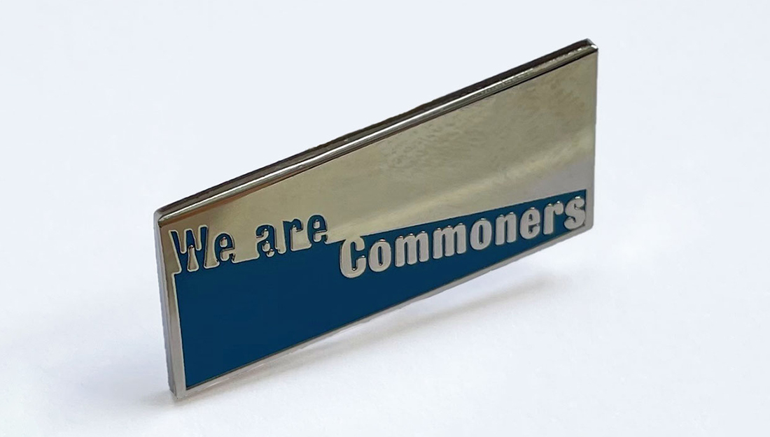 An enamel badge of the We are Commoners logo.