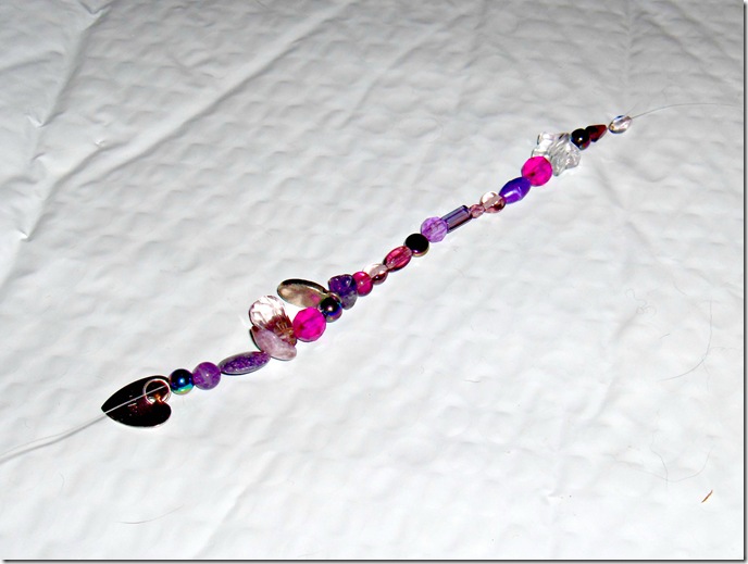 Wire and bead bookmarks CreativeCynchronicity.com beads being strung on fishing line for a beaded wire bookmark, assorted shapes and shades of pinks and purples