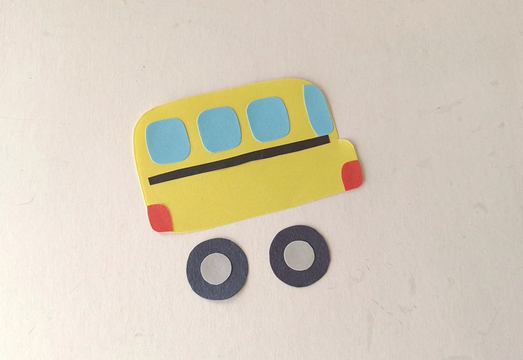 School bus with windows, trim, and lights glued onto the paper bus body.