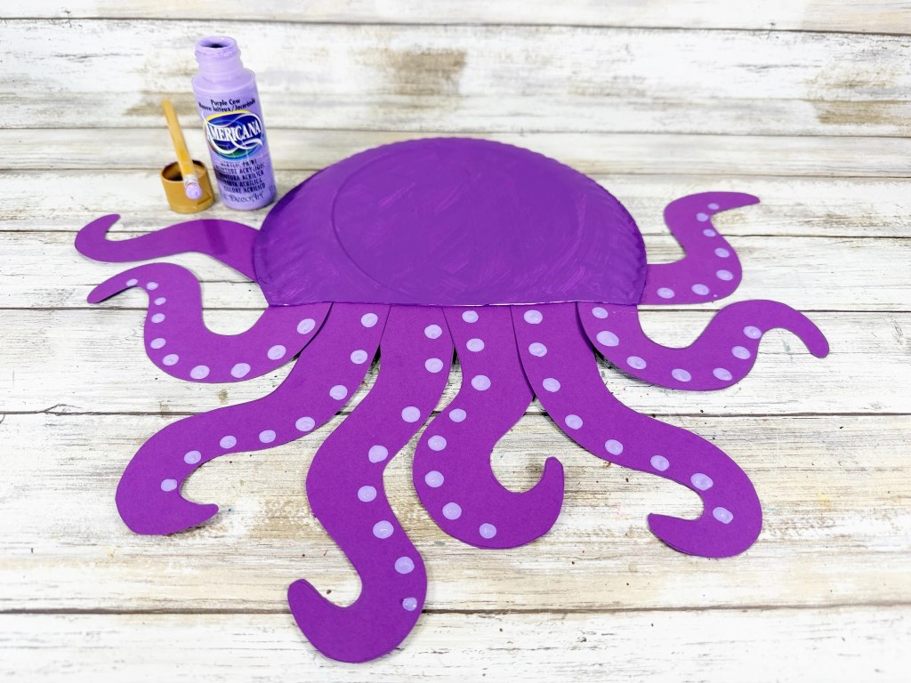 Painting light purple suckers onto each octopus arm.