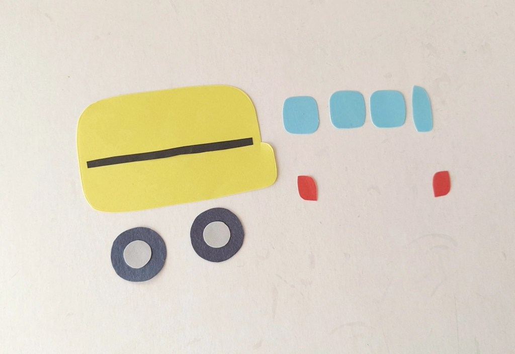 Paper pieces for assembling the school bus before gluing the windows and wheels in place.