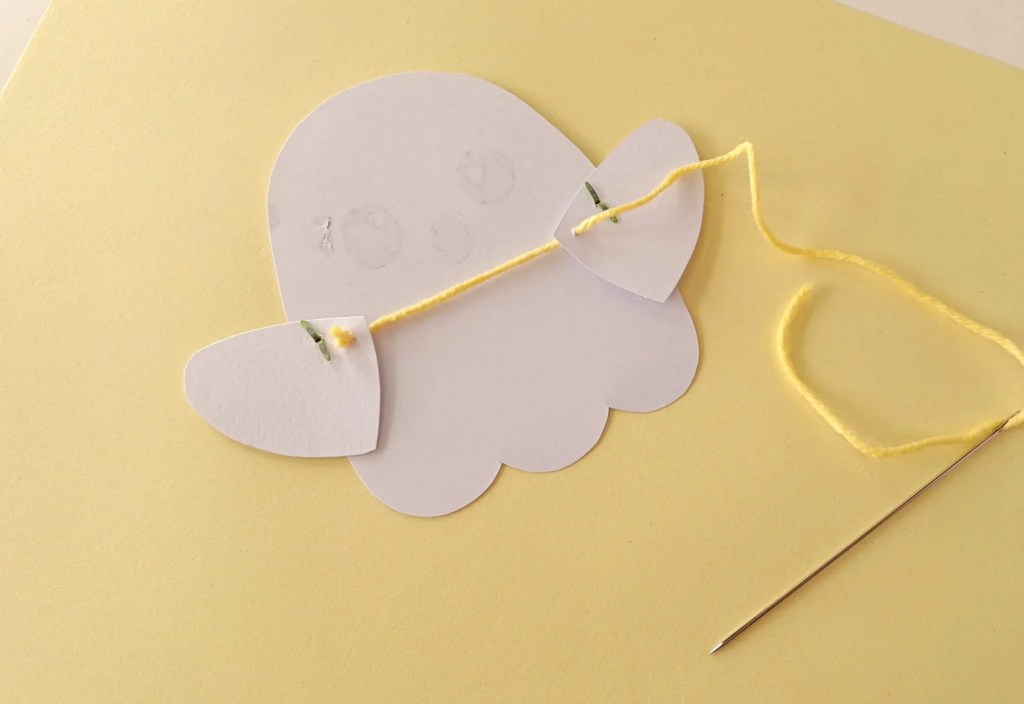 Yellow yarn being threaded through the right ghost arm