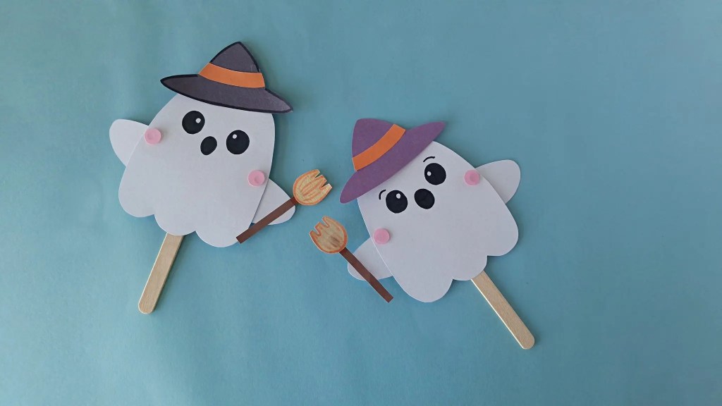 Pair of moving ghost puppets posed with their arms raised and lowered