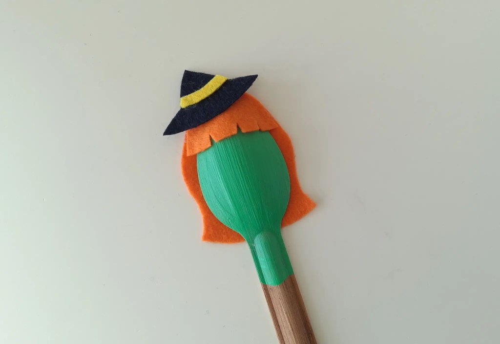 Black felt witch hat added above the orange hair on the spoon.