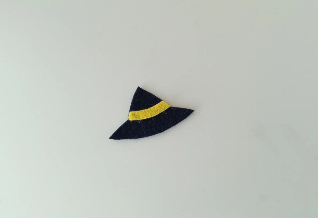 Black felt witch hat decorated with a yellow hatband.