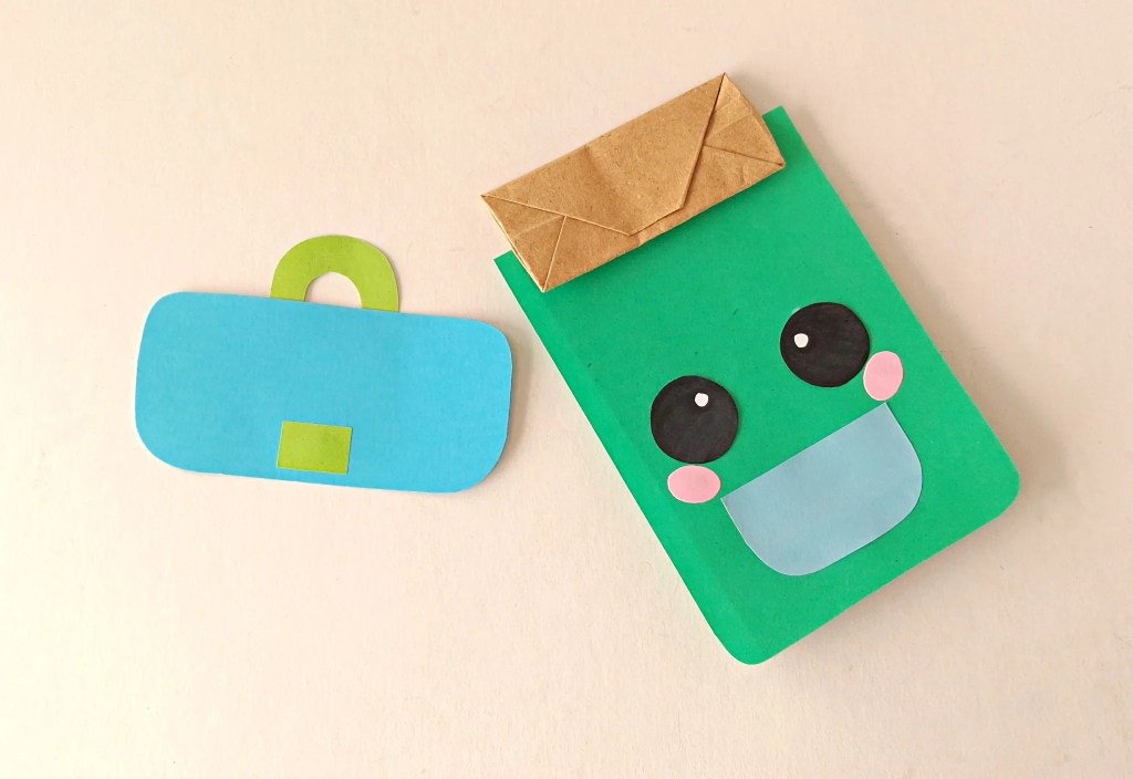 Green backpack base and face attached to a paper bag with the flap ready to add.