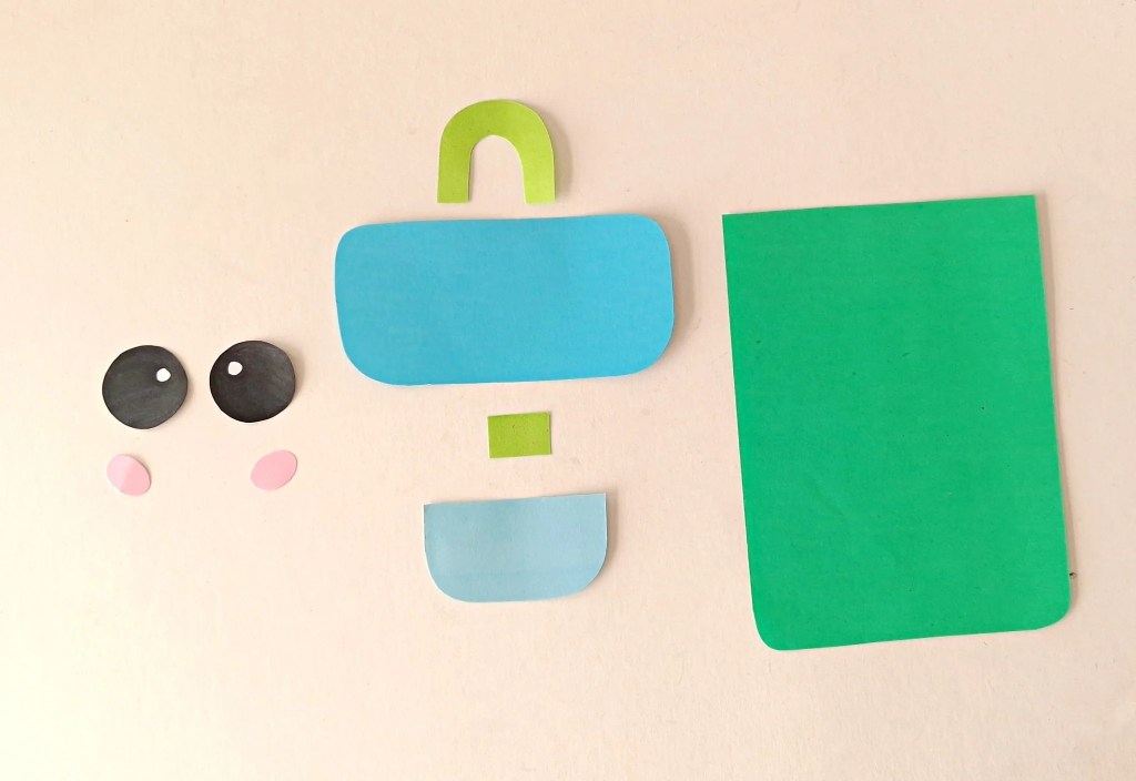 Colorful paper template pieces cut out for making a paper bag backpack puppet.