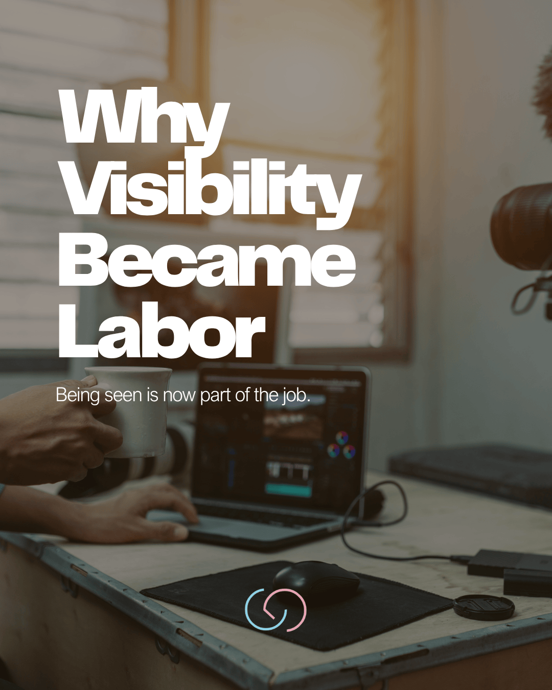 A person's hand holding a coffee cup while using a laptop with editing software on a wooden desk. Text overlay reads 'Why Visibility Became Labor' with a subtitle 'Being seen is now part of the job.'