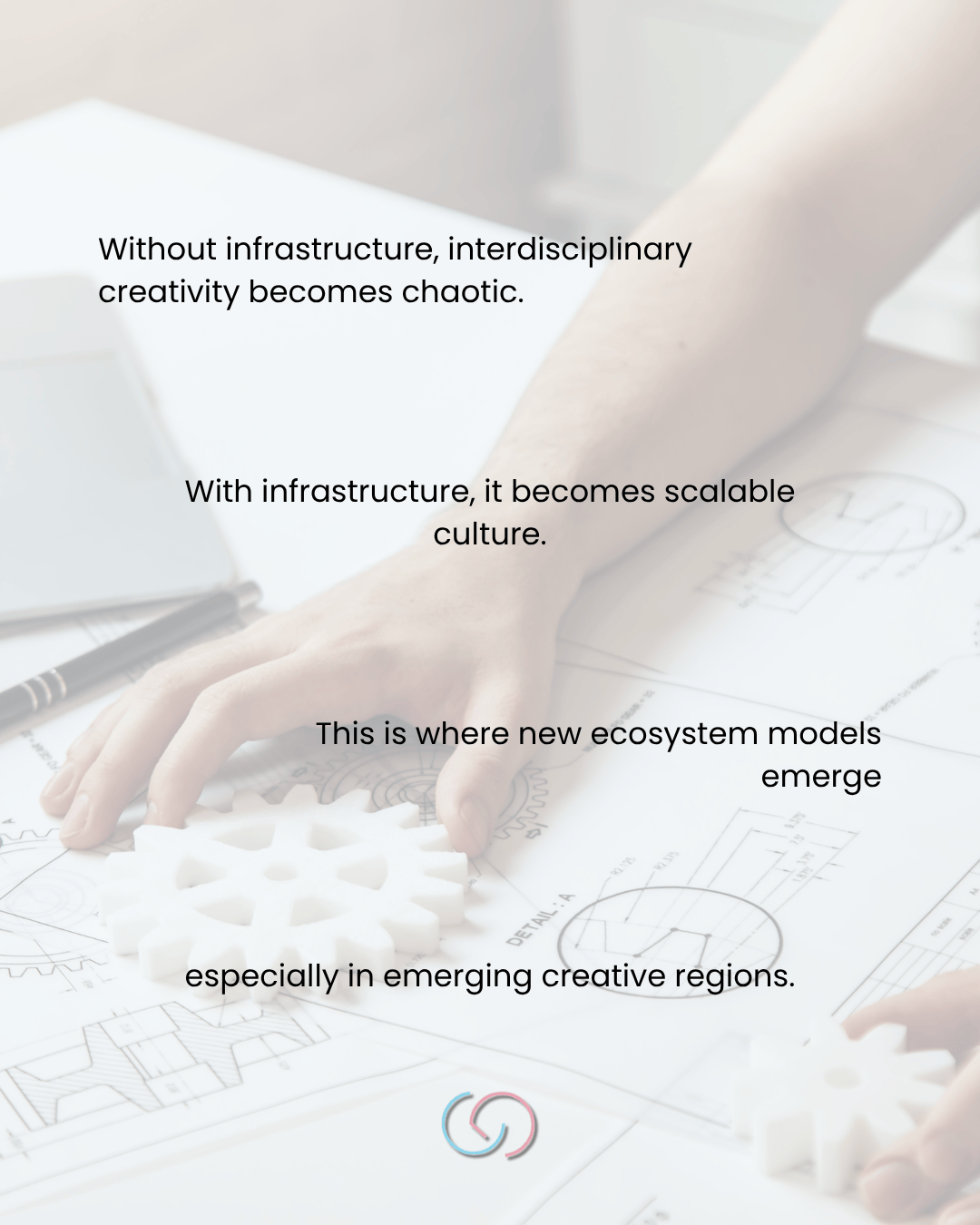 Hand reaching for a white gear model on an architectural drawing with text discussing infrastructure and creativity.