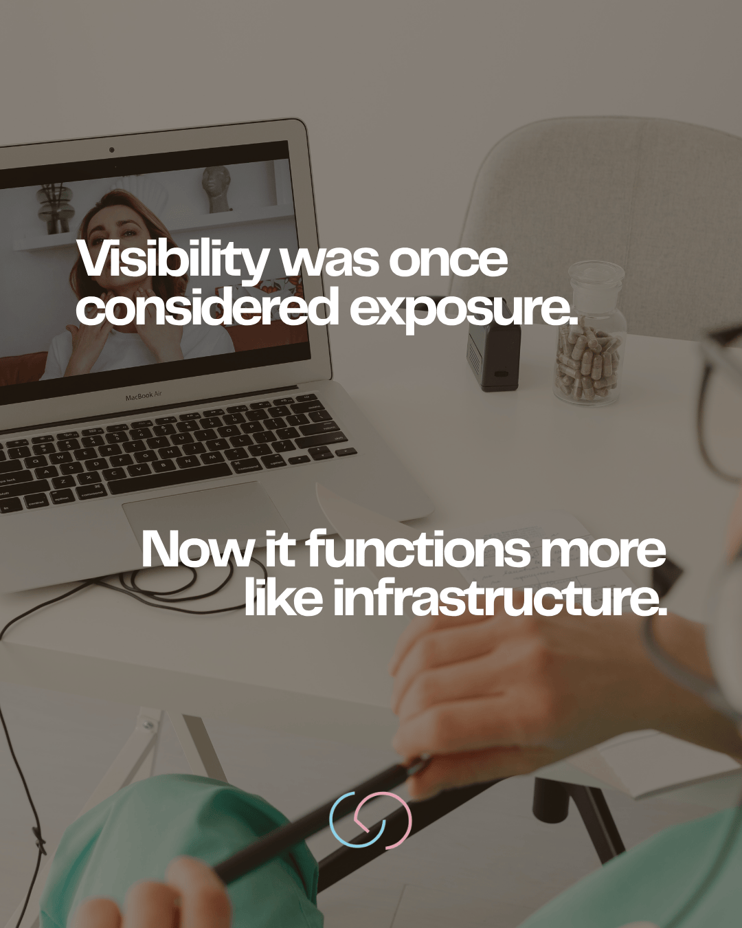 A laptop displaying a video call with a woman, accompanied by text overlay discussing the evolution of visibility from exposure to infrastructure, with a person's hand holding a pen and a notepad in the foreground.