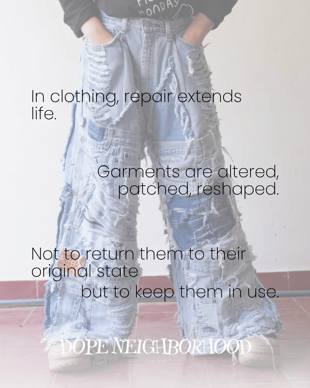 A person wearing oversized, distressed denim pants with visible patches and alterations, emphasizing clothing repair for sustainability.