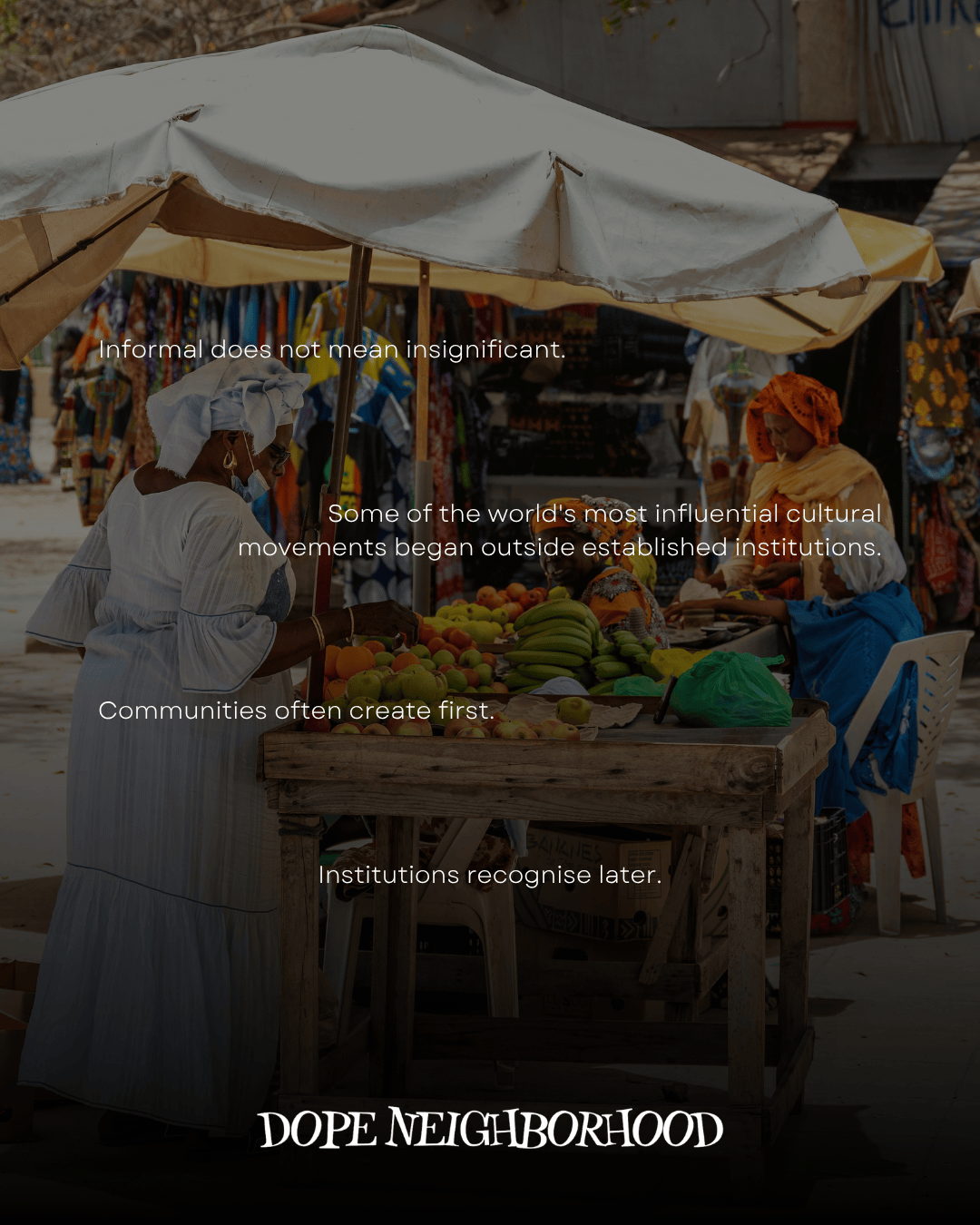 A vibrant outdoor market scene featuring a woman in traditional attire at a fruit stand, with colorful fabrics and textiles displayed in the background.