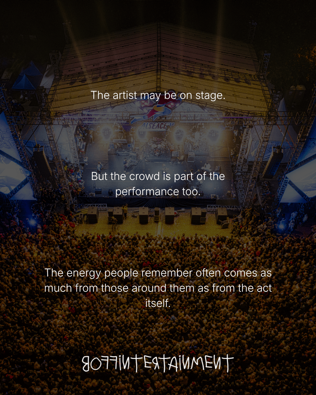Aerial view of a lively concert with a large crowd in front of a stage.