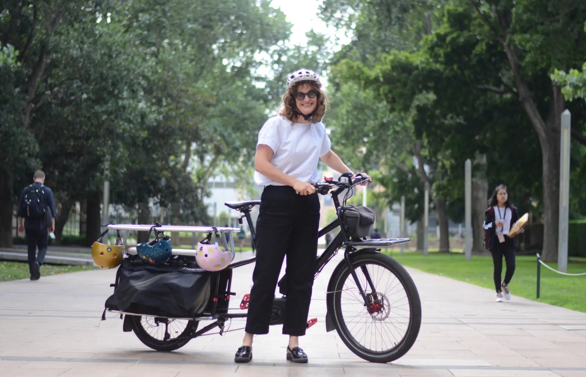 CRED Consulting, Woman smiling with ther bike in a park, CRED Consulting
