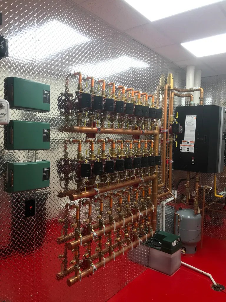 Boiler room showing red floor and silver diamond plate backing. Clean and organized rows of piping and meters