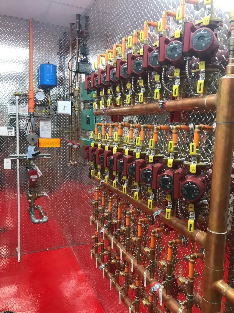 Boiler room manifold showing silver diamond plate backing and clean organized rows
