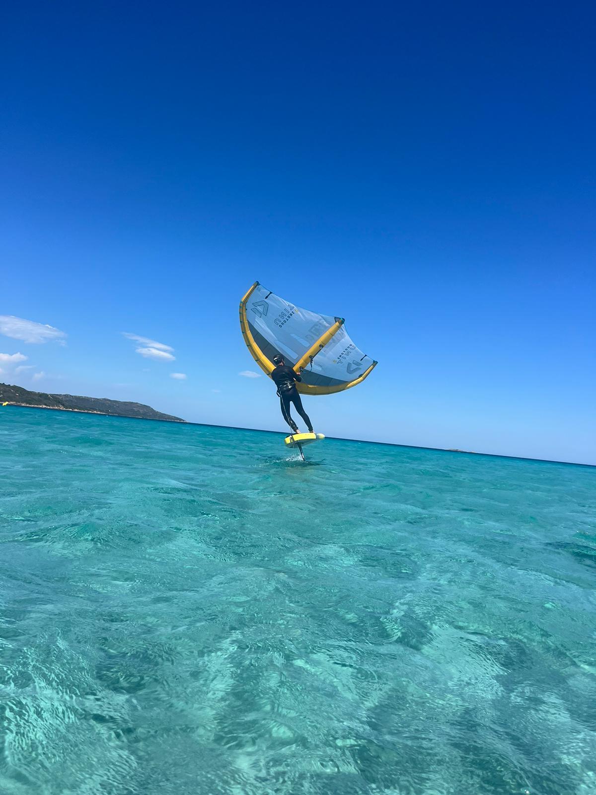 Rider en wingfoil au-dessus d'une eau turquoise en Sardaigne