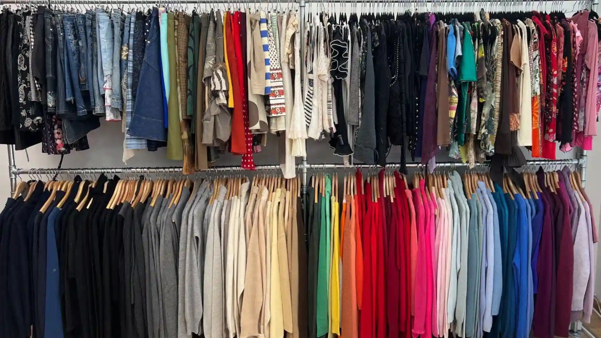 Double portant du rez-de-chaussée de Pépites, vêtements vintage classés par couleur.