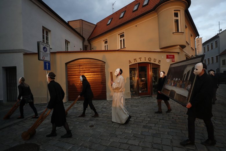 Participants dressed in black, wearing masks, beating drums and pushing small carts making a synchronized and loud sound take part in an Easter procession marching through the streets of Ceske Budejovice, Czech Republic, Thursday, April 1, 2021. (AP Photo/Petr David Josek)