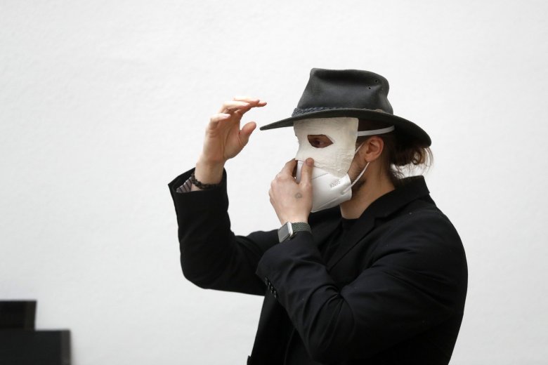 A participant adjusts his masks before taking part in an Easter procession marching through the streets in Ceske Budejovice, Czech Republic, Thursday, April 1, 2021. (AP Photo/Petr David Josek)