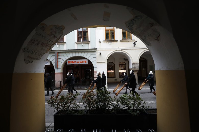 Participants dressed in black, wearing masks, beating drums and pushing small carts making a synchronized and loud sound take part in an Easter procession marching through the streets of Ceske Budejovice, Czech Republic, Friday, April 2, 2021. (AP Photo/Petr David Josek)
