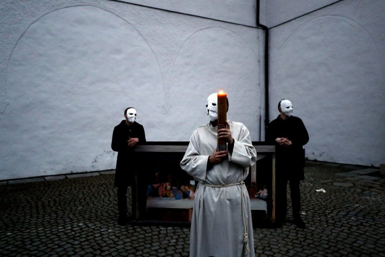 Participants wearing masks stand near a depiction of the painting the Last Supper take part in an Easter procession marching through the streets of Ceske Budejovice, Czech Republic, Thursday, April 1, 2021. (AP Photo/Petr David Josek)