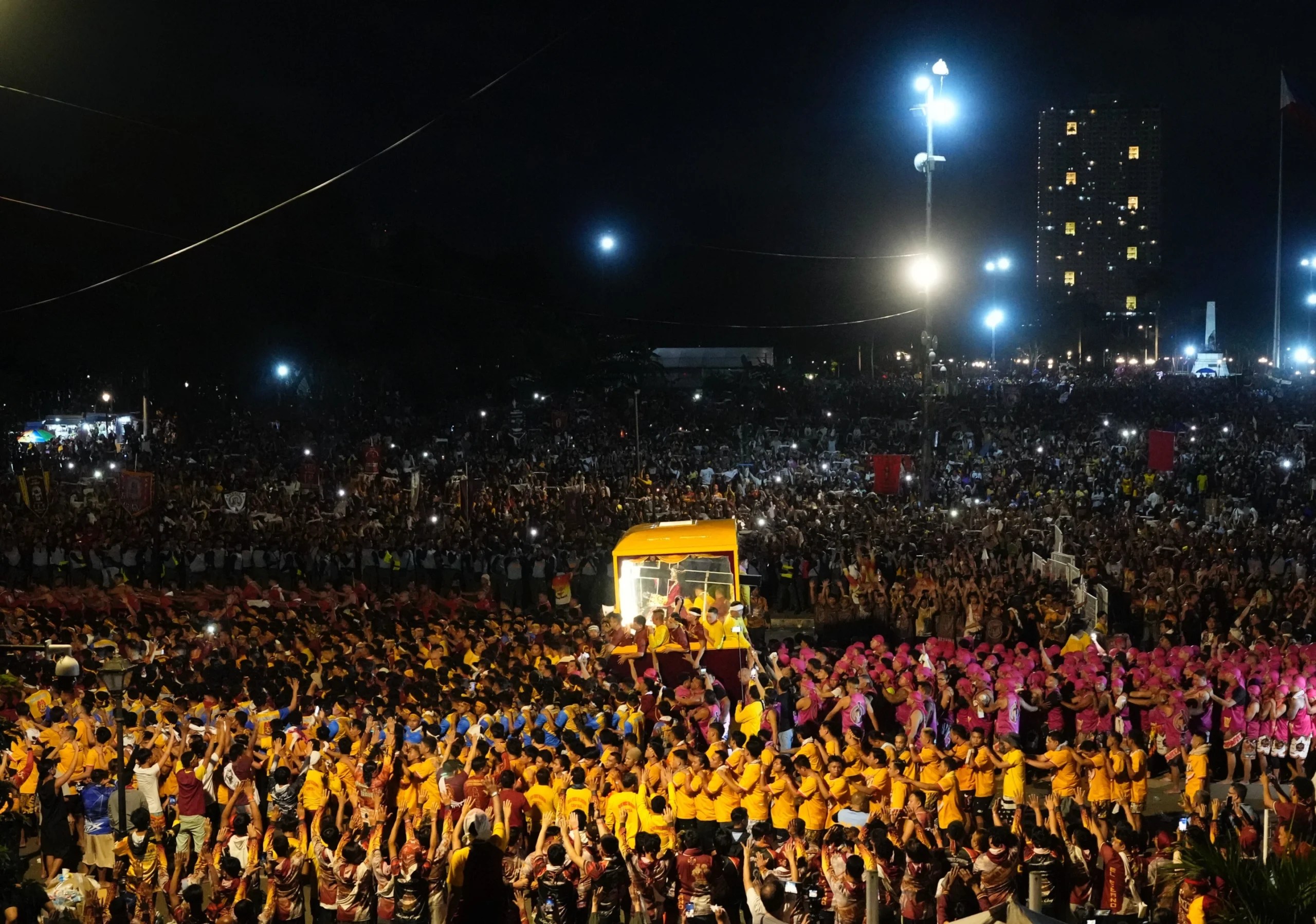 Catholic devotees walk beside a glass-covered carriage carrying the image of Jesus Nazareno during its annual procession in Manila, Philippines, on its feast day, Friday Jan. 9, 2026. (Credit: Aaron Favila/AP.)
