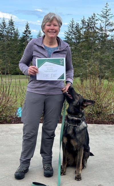 Woman standing with a dog next to her