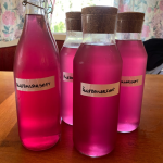 Bottles filled with pink fireweed meadonwsweet lemonade