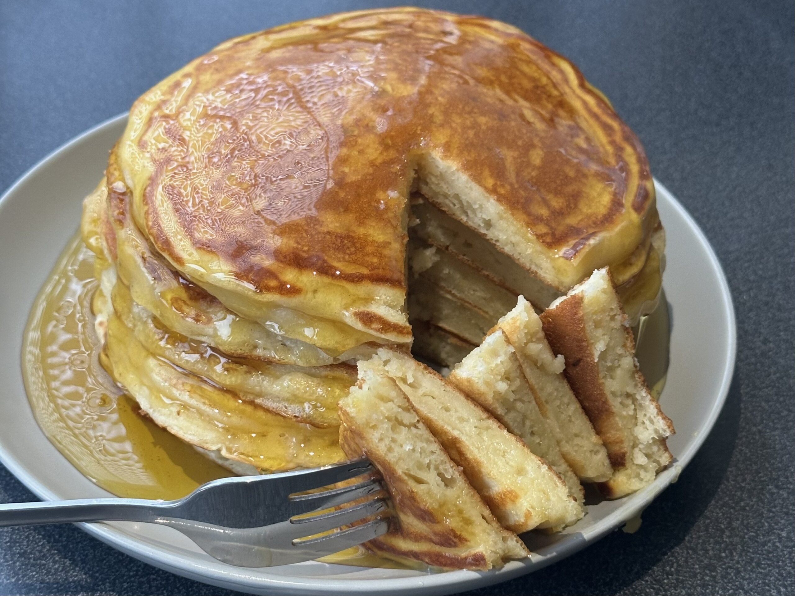 High protein Greek yoghurt pancakes, covered in syrup and sliced.