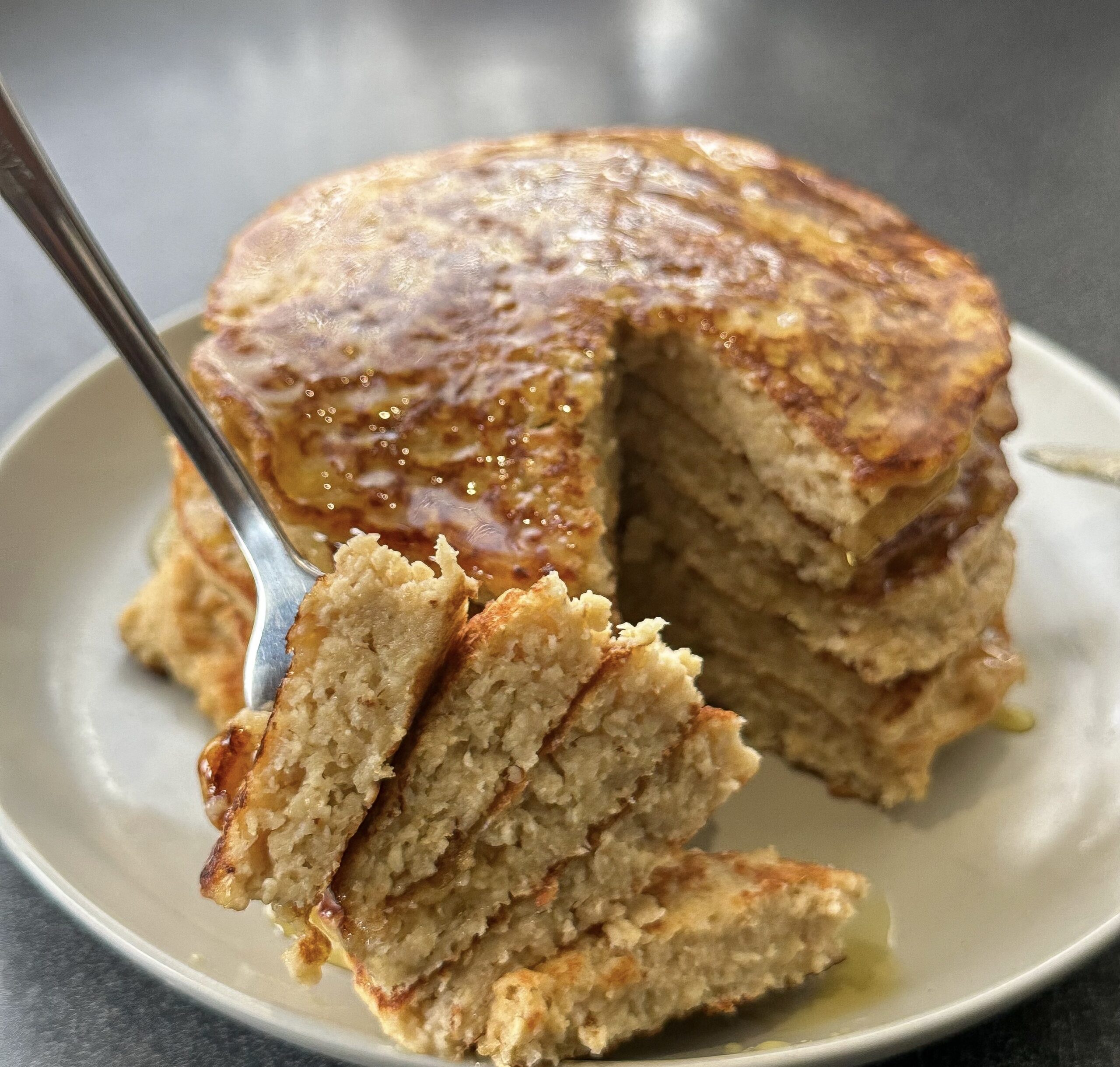A stack of Oat Banana Pancakes cut, with a slice cut out.