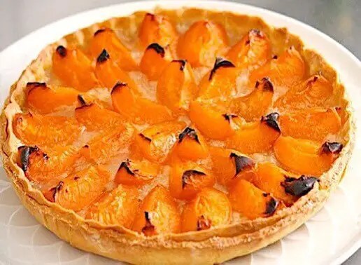 tarte aux abricots dorée à la crème d'amande sur pâte feuilletée