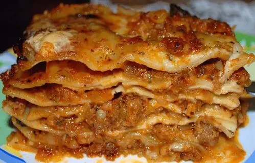 Lasagnes bolognaises gratinées dans leur plat, une part servie montrant les couches