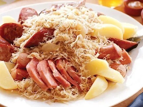 Choucroute garnie alsacienne servie avec saucisses de Strasbourg, lard, carré de porc et pommes de terre