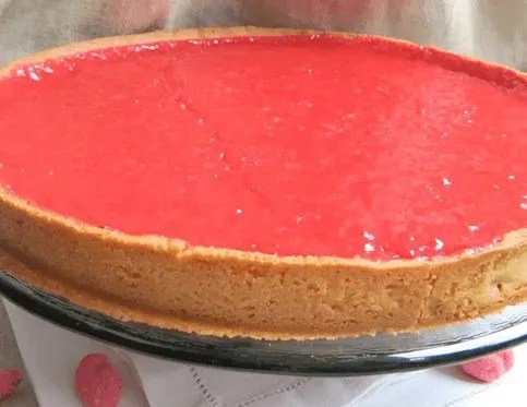 Tarte aux pralines roses de Lyon, part découpée montrant la crème de pralines fondante sur pâte sablée