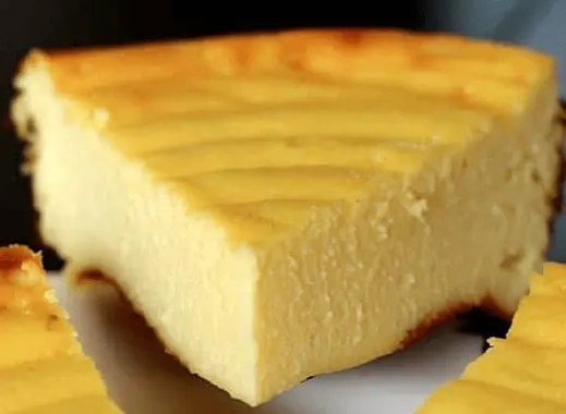 Flan pâtissier de ménage doré, une part coupée montrant la garniture au fromage de brebis